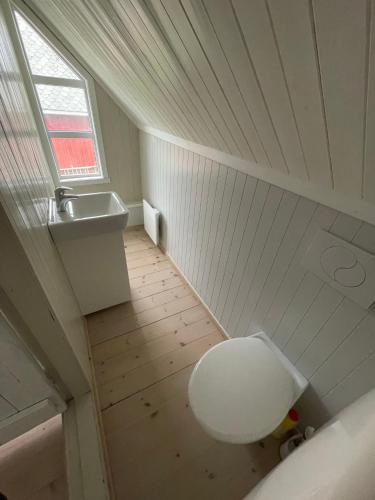 an attic bathroom with a toilet and a sink at Stasjonen - Sørvågen in Moskenes