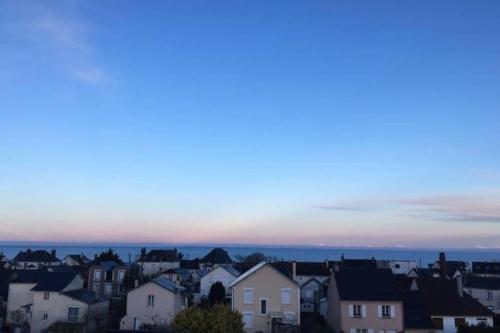 Blick auf eine Stadt mit Häusern in der Dämmerung in der Unterkunft Donville vue sur la mer in Donville-les-Bains