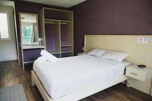 een slaapkamer met een groot wit bed en een raam bij JH Hotel Tlatlauqui in Tlatlauquitepec