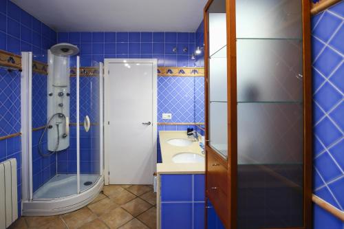 y baño azul con lavabo y ducha. en LUXEZEN Planetcostadorada en Reus