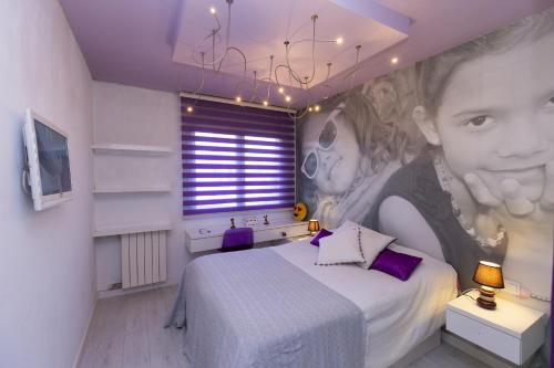 1 dormitorio con 1 cama con una pintura de un niño en LUXEZEN Planetcostadorada en Reus