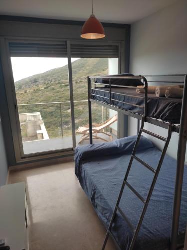 a bunk bed in a room with a large window at Casamuler in Peniscola