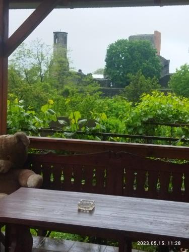 a teddy bear sitting on a bench with a watch at Vár-Liget Vendégház in Kisnána