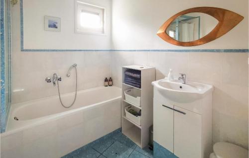 ein Badezimmer mit einer Badewanne, einem Waschbecken und einem Spiegel in der Unterkunft 2 Bedroom Gorgeous Home In Lemmer in Lemmer