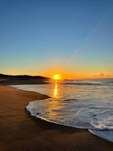 a sunset on a beach with the ocean at Gotita in Yolina