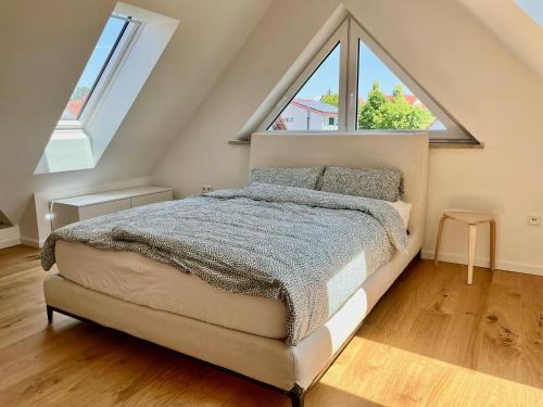 a bedroom with a bed with a large window at Tolle Maisonette Wohnung mit Seeblick - Ferienwohnung Seeliebe in Büchelberg
