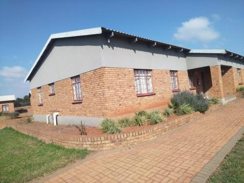 a brick building with windows on a brick road at KUNGWINI ACADEMY CENTRE in Bronkhorstspruit