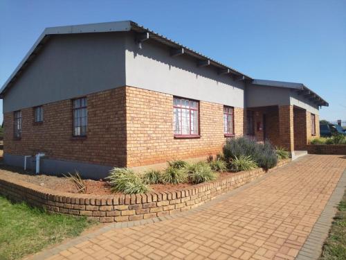 a brick building with windows and a brick driveway at KUNGWINI ACADEMY CENTRE in Erasmus