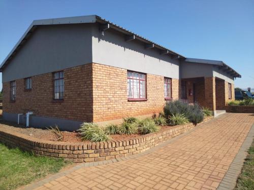 a brick building with windows and a brick driveway at KUNGWINI ACADEMY CENTRE in Bronkhorstspruit