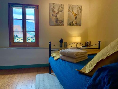 Un dormitorio con una cama azul y una ventana en Apartment with mountain views in town centre, en La Roche-sur-Foron