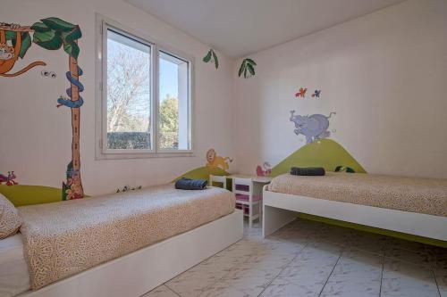 a bedroom with two beds and a window at Villa Paris Garden - 15 minutes de Disneyland Paris in Montévrain