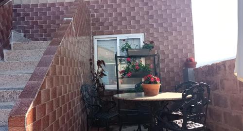 a brick wall with a table and chairs and a window at A Niñada in Marín