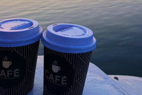 Dos tazas de café junto al agua en GuestBoat Milagre en Faro