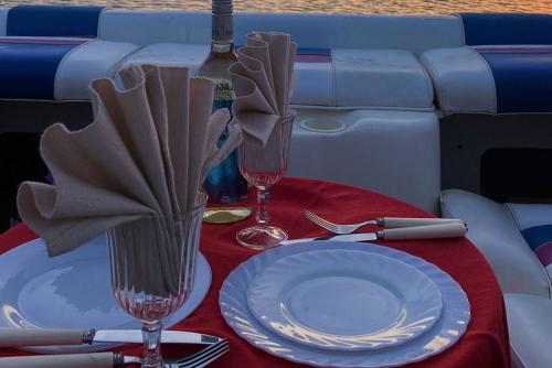 una mesa con un plato y dos copas de vino en GuestBoat Milagre, en Faro
