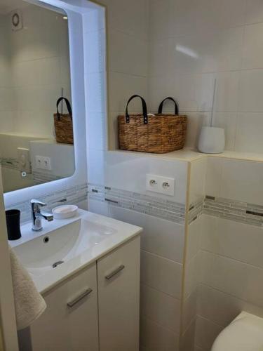 une salle de bain blanche avec un lavabo et un miroir dans l'établissement T2 neuf indépendant dans villa proche des plages, à La Seyne-sur-Mer