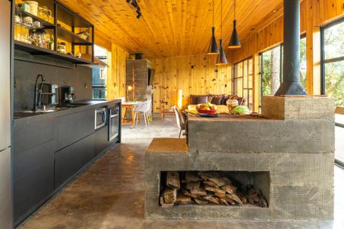 a kitchen with a fireplace in the middle of a house at Vivenda das Araucárias in Rio Rufino