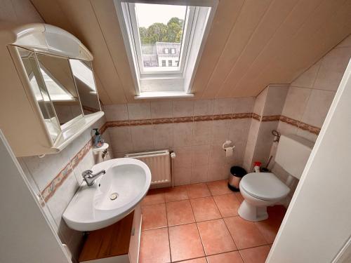 een badkamer met een wastafel en een toilet en een raam bij Ferienhaus Flensburg Sandberg in Flensburg