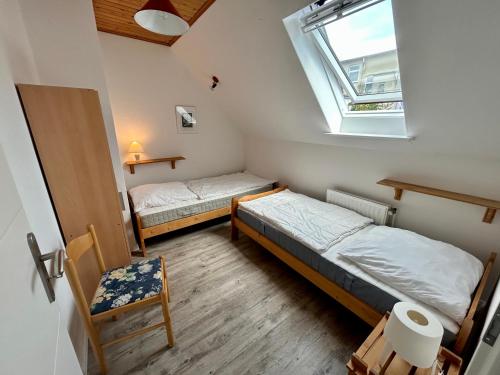 twee bedden in een kleine kamer met een raam bij Ferienhaus Flensburg Sandberg in Flensburg