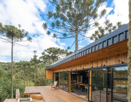 a house in the woods with a large deck at Cabana na Serra Lareira e Vista Deslumbrante in Rio Rufino
