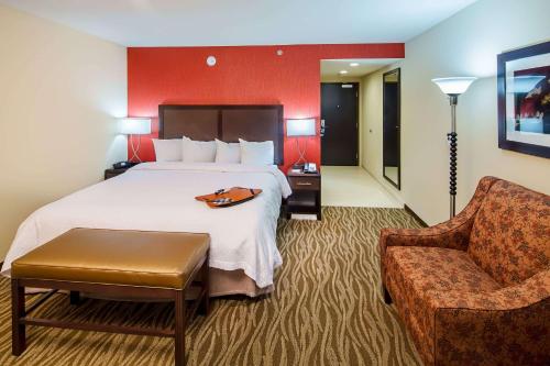 um quarto de hotel com uma cama e uma cadeira em Hampton Inn by Hilton Augusta Fort Eisenhower em Augusta