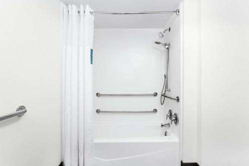 eine Dusche im Bad mit einem weißen Duschvorhang in der Unterkunft Hampton Inn Amelia Island in Fernandina Beach