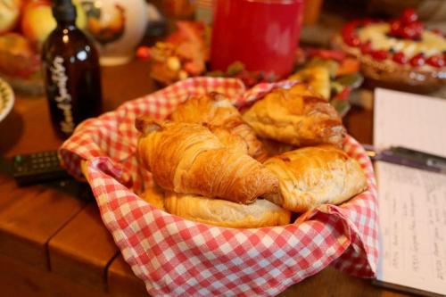 een mand met croissants en andere zoete deegwaren op een tafel bij Bumbleberry Cottage in Gresford