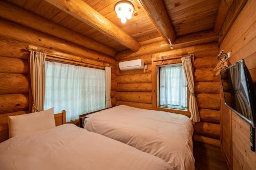 1 dormitorio con 2 camas en una cabaña de madera en Log house Grazzi - Vacation STAY 70263v, en Nasu-yumoto