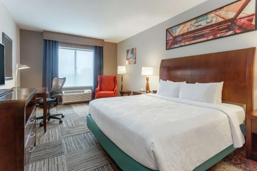 a hotel room with a bed and a desk and chair at Hilton Garden Inn Albany-SUNY Area in Albany