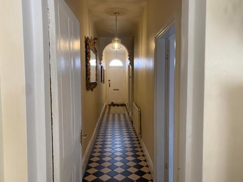 a long hallway with a blue and white checkered floor at Albany house in Birmingham