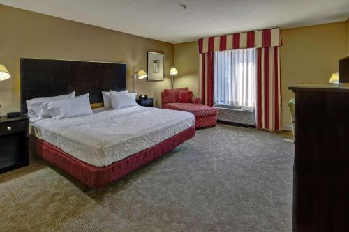 Habitación de hotel con cama y silla en Hampton Inn Jacksonville en Jacksonville