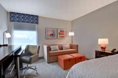 ein Hotelzimmer mit einem Bett, einem Schreibtisch und einem Stuhl in der Unterkunft Hampton Inn Anderson in Anderson