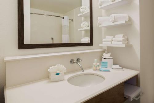 a bathroom with a sink and a mirror and towels at Hampton Inn Bonita Springs Naples North in Bonita Springs