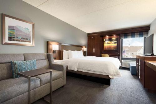 a hotel room with a bed and a couch at Hampton Inn Appleton-Fox River Mall Area in Appleton