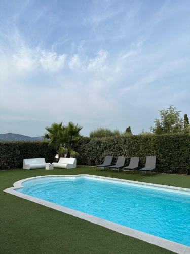 - une piscine avec des chaises longues à côté d'un complexe dans l'établissement Villa golfe de saint tropez, à Cogolin