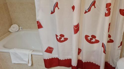 a bathroom with a red and white shower curtain at Apartamentos Vera Coast in Vera