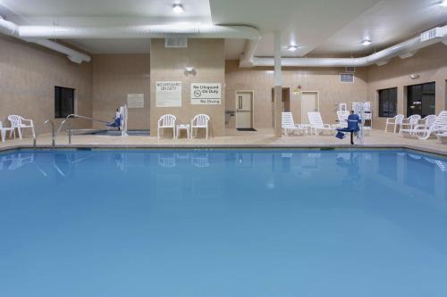 a large swimming pool with white chairs and chairs at Hampton Inn & Suites Astoria in Astoria, Oregon