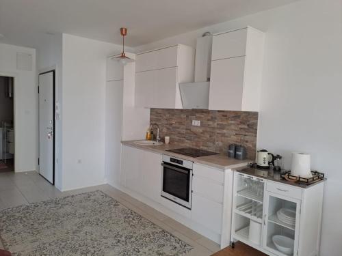 a kitchen with white cabinets and a stove top oven at La Mar in Pag