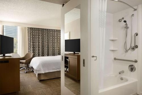 a hotel room with a bed and a bathroom with a tub at Hampton Inn Atlanta-Buckhead in Atlanta
