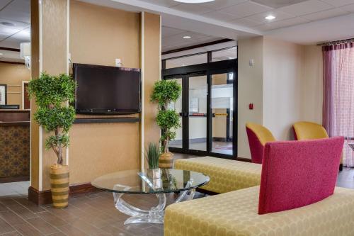 a lobby with chairs and a table and a tv at Hampton Inn Atlanta-Fairburn in Fairburn