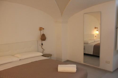a hotel room with a bed and a mirror at Il Palazzotto in Fasano
