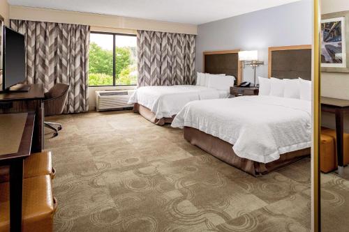 a hotel room with two beds and a desk at Hampton Inn Atlanta-Fairburn in Fairburn