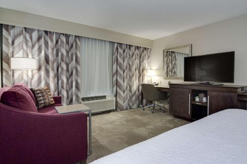 a hotel room with a bed and a desk and a tv at Hampton Inn Atlanta-Fairburn in Fairburn
