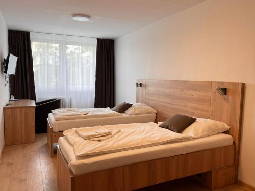 sypialnia z 2 łóżkami i oknem w obiekcie Garni Hotel Akadémia w Koszycach