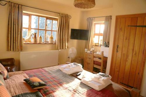a bedroom with a bed with two towels on it at Bumbleberry Cottage in Gresford