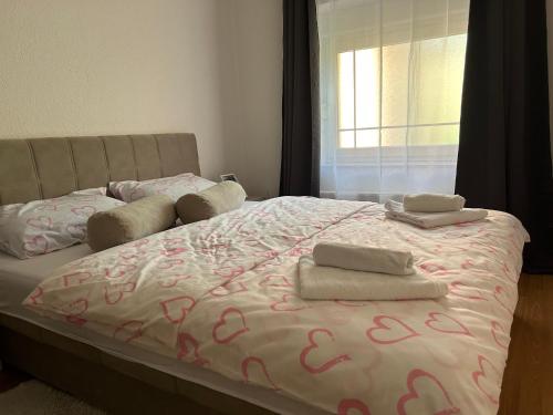 uma cama com duas toalhas com uma janela em Apartman D&D em Jajce