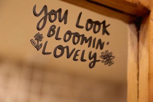 a sign that says you look bloomin lovely at Bumbleberry Cottage in Gresford