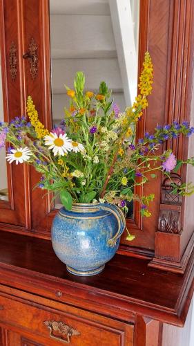 a blue vase filled with flowers on top of a cabinet at BED & BREAKFAST für Individualisten in Gemeinde Scharbeutz, auch Allergiker in Scharbeutz