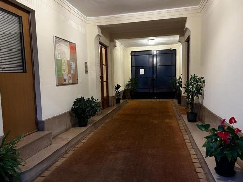 un couloir avec une porte bleue dans un bâtiment dans l'établissement Appartement Paris 16eme, à Paris