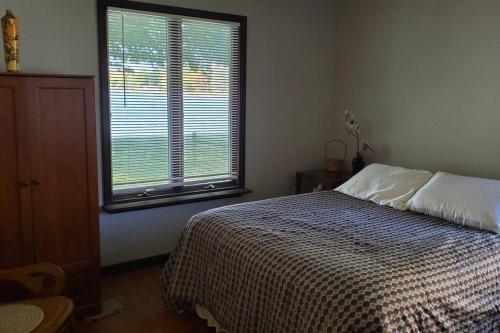 sypialnia z łóżkiem i dużym oknem w obiekcie Serenity Sunset w mieście Brocton