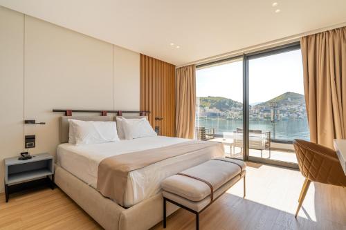 sypialnia z dużym łóżkiem i dużym oknem w obiekcie Yacht Premium Hotel w Sarandzie